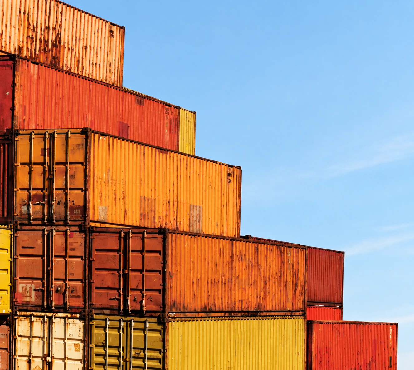 Stacked shipping containers against a blue sky